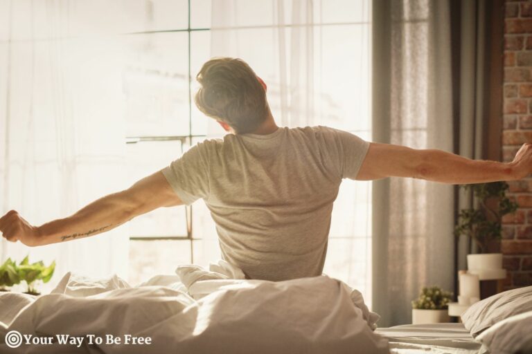Young Man Waking up in the Morning, Stretches and Gets Out of Bed, Sun Shines From the Apartment Window in Bedroom, he wakes up refreshed and energized with 6 Proven Sleep Hacks
